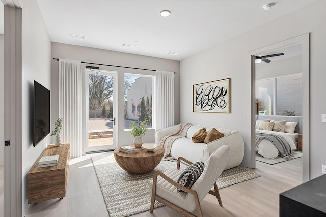 living area with light wood finished floors and ceiling fan