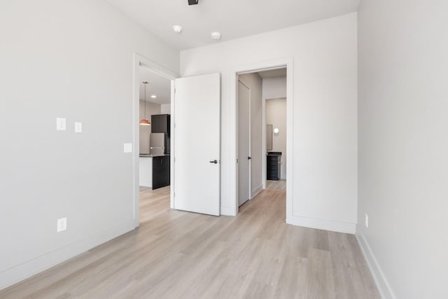 unfurnished bedroom with light wood-type flooring and baseboards