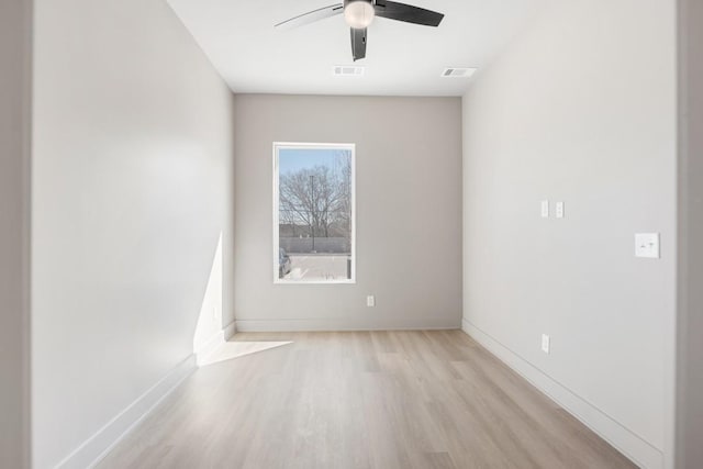 unfurnished room with wood finished floors, a ceiling fan, and baseboards