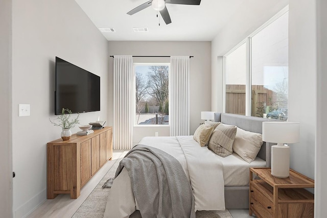 bedroom featuring baseboards, light wood-style floors, and ceiling fan