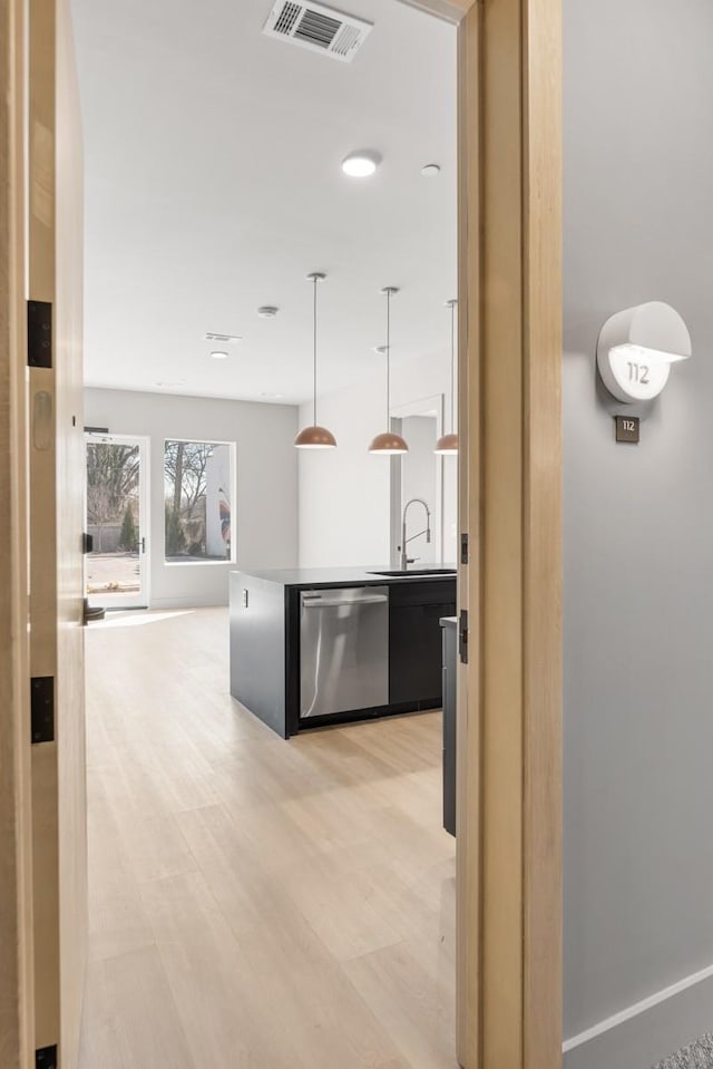 hallway with light wood-style flooring and a sink