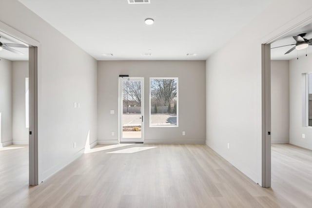 empty room featuring a ceiling fan, light wood-style flooring, and baseboards