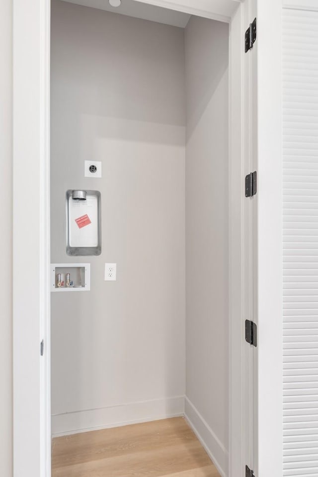 laundry room featuring electric dryer hookup, light wood finished floors, washer hookup, and baseboards