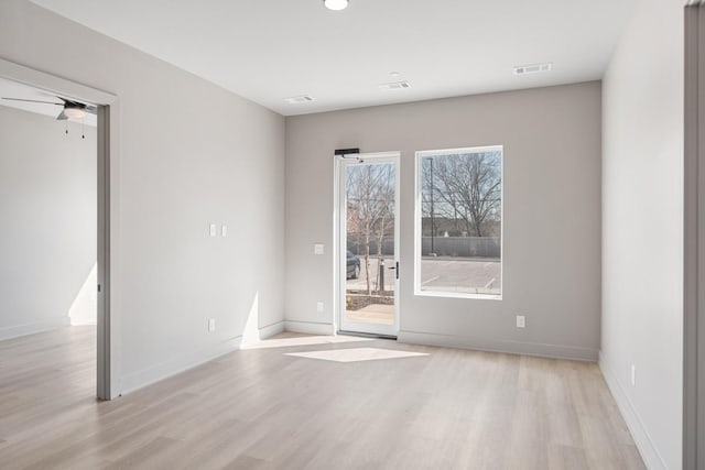 empty room featuring wood finished floors, baseboards, and ceiling fan