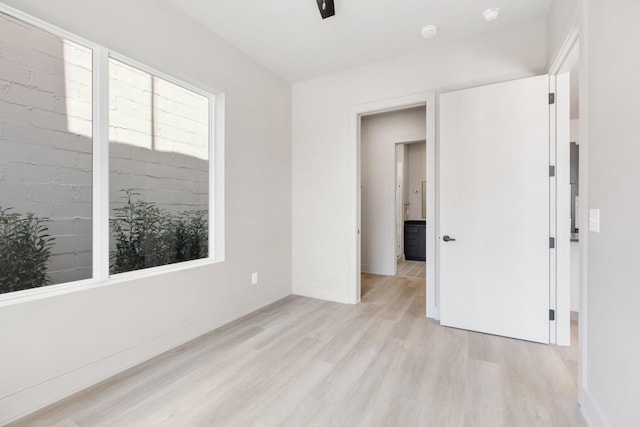 spare room with light wood-style flooring and baseboards