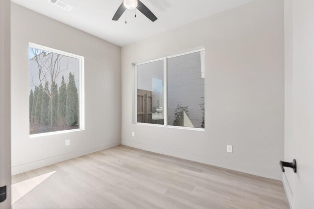 empty room with ceiling fan, wood finished floors, and baseboards