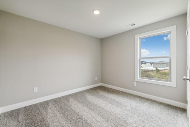 unfurnished room with visible vents, baseboards, and carpet