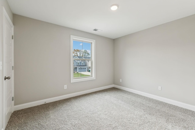 carpeted spare room with visible vents and baseboards
