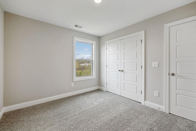 unfurnished bedroom featuring baseboards, a closet, visible vents, and carpet