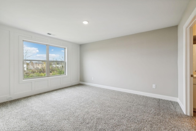 carpeted empty room with visible vents and baseboards