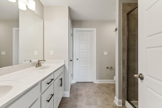 bathroom with a sink, double vanity, baseboards, tile patterned flooring, and a shower stall
