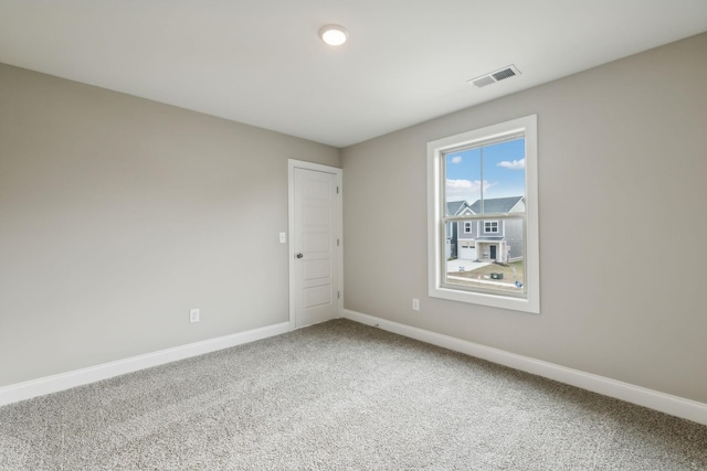 spare room with baseboards, carpet flooring, and visible vents