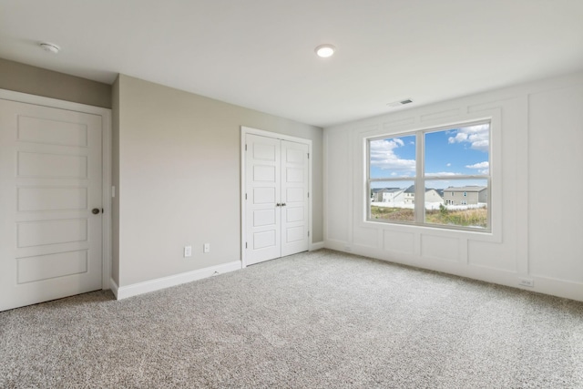 unfurnished bedroom featuring recessed lighting, visible vents, carpet floors, a closet, and baseboards