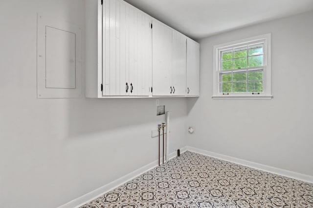 washroom with cabinet space, washer hookup, electric panel, and baseboards