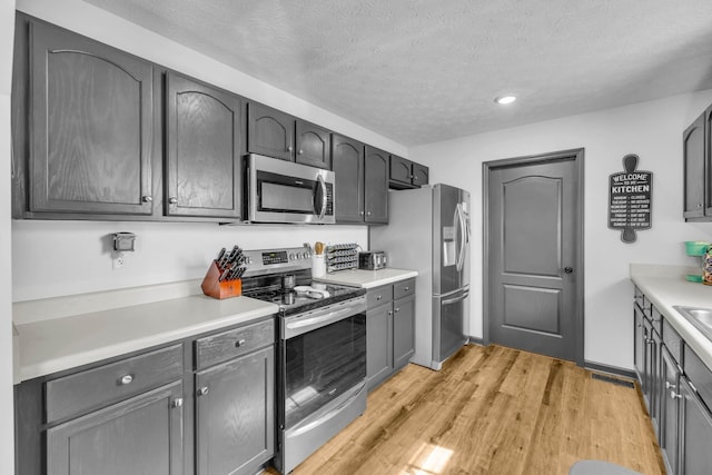 369 Talpha Dr, Dowelltown, TN 37059 - kitchen with light wood-style flooring, a textured ceiling, recessed lighting, light countertops, and appliances with stainless steel finishes