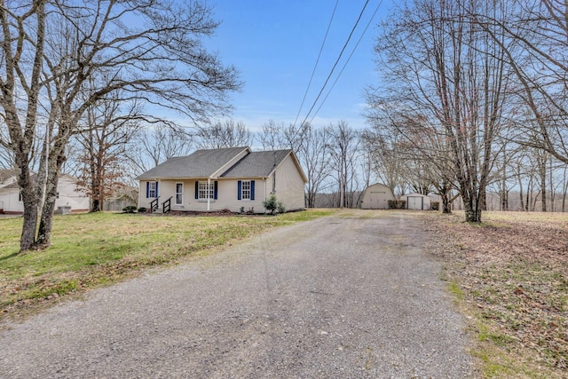 369 Talpha Dr, Dowelltown, TN 37059 - view of front of home featuring gravel driveway, a front lawn, a storage unit, and an outdoor structure