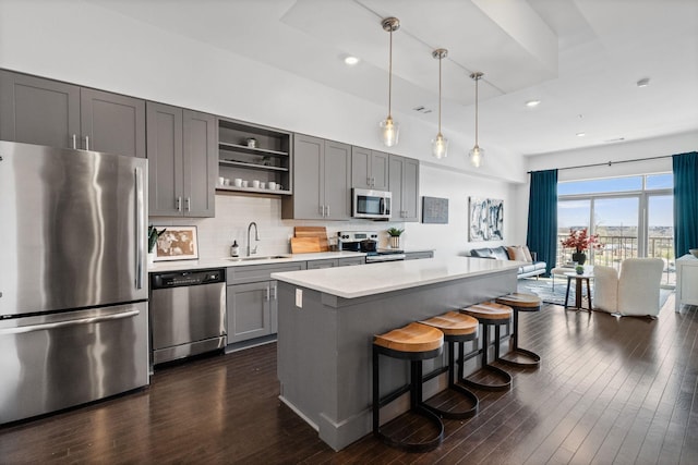 kitchen with open shelves, a sink, gray cabinets, stainless steel appliances, and light countertops