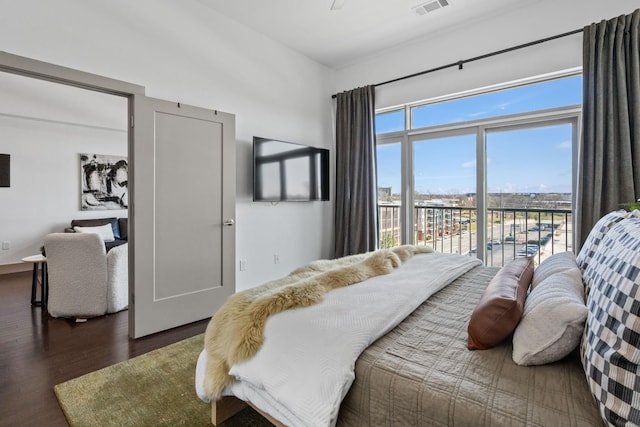 bedroom with dark wood finished floors, visible vents, and access to outside