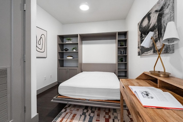 bedroom with baseboards and wood finished floors
