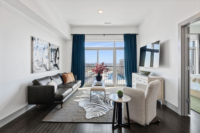 living area featuring dark wood-type flooring, visible vents, baseboards, and recessed lighting