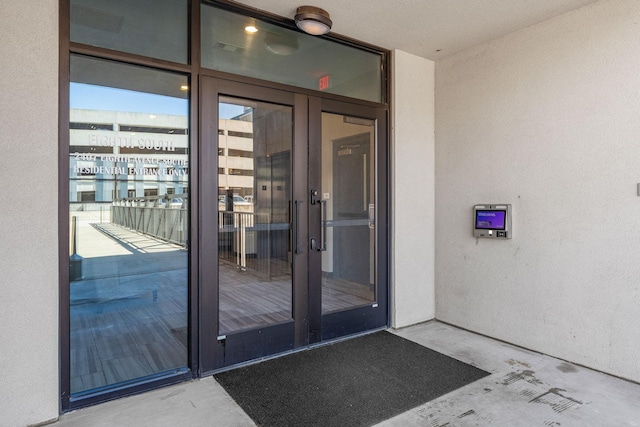entrance to property featuring a balcony and stucco siding