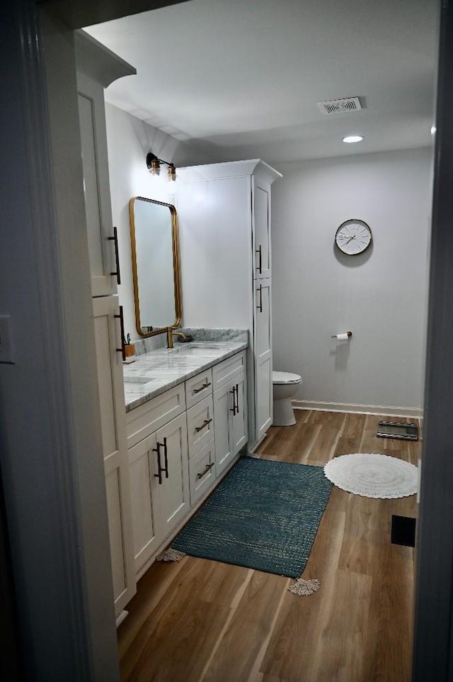 4310 Memory Ln, Adams, TN 37010 - bathroom featuring double vanity, wood finished floors, toilet, and baseboards