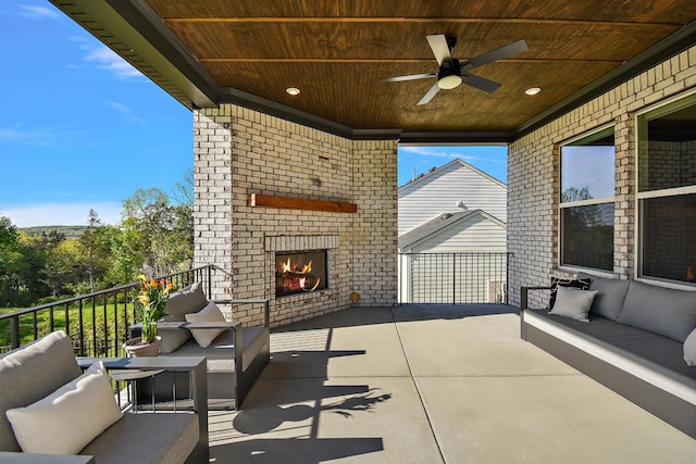 view of patio / terrace with an outdoor living space with a fireplace and ceiling fan