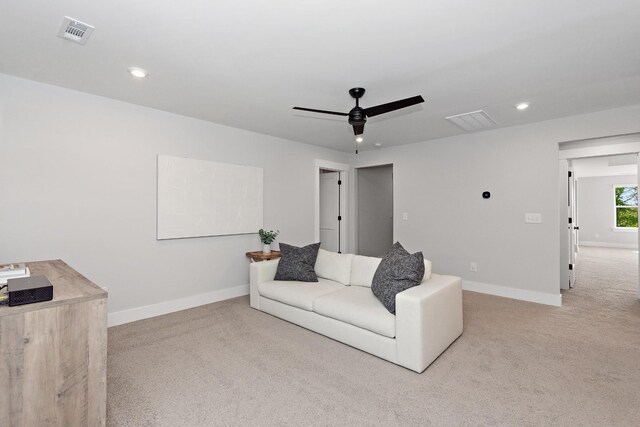 living area with baseboards, ceiling fan, light carpet, and visible vents