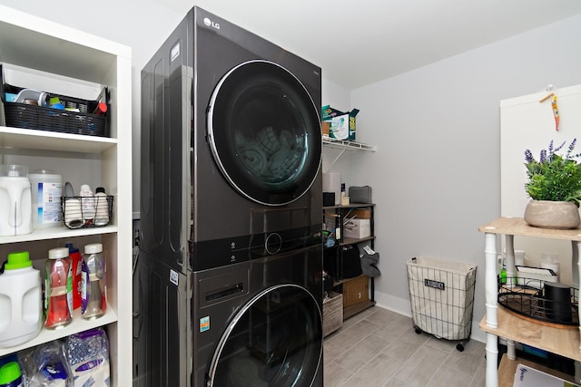 laundry room featuring laundry area, baseboards, and stacked washer / drying machine