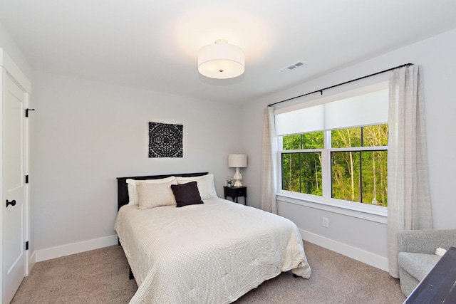 carpeted bedroom featuring baseboards and visible vents