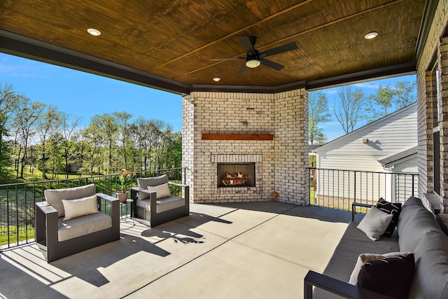 view of patio / terrace featuring ceiling fan and an outdoor living space with a fireplace