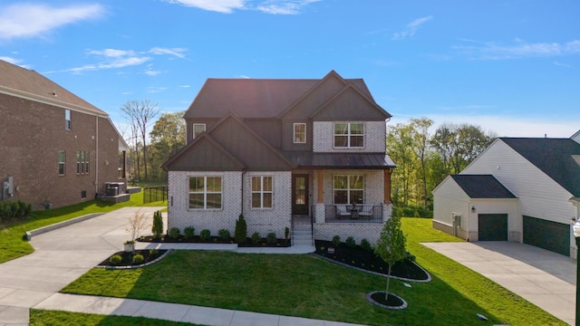 view of front of home with concrete driveway, brick siding, a front yard, and a porch