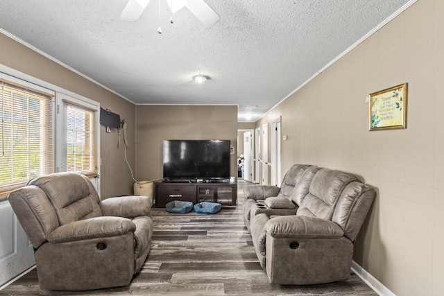 living area featuring ornamental molding, a textured ceiling, a ceiling fan, and wood finished floors