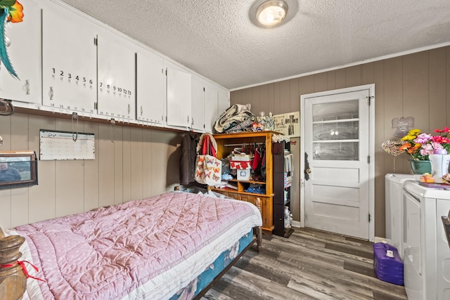 bedroom with a textured ceiling, wood finished floors, and separate washer and dryer