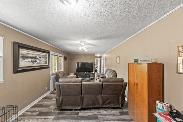 living area featuring ornamental molding, ceiling fan, a textured ceiling, and wood finished floors