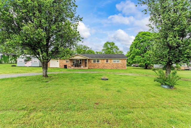 view of front of property with brick siding, driveway, and a front yard