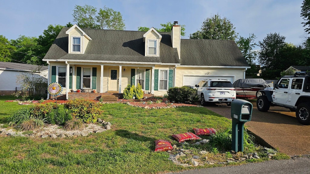 cape cod-style house with a garage, a chimney, concrete driveway, a porch, and a front yard