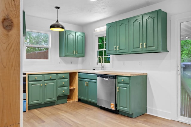 kitchen featuring light wood-style flooring, a sink, dishwasher, light countertops, and decorative light fixtures