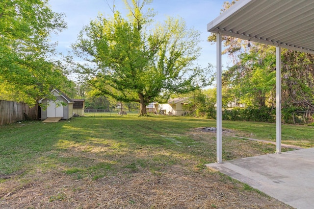 view of yard featuring a fenced backyard, a storage unit, and an outbuilding