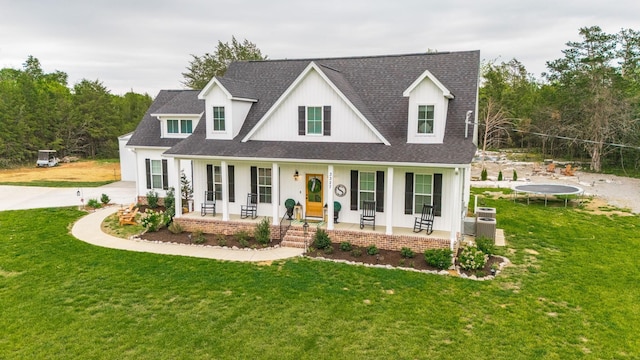 modern inspired farmhouse featuring driveway, a porch, a trampoline, and a front yard