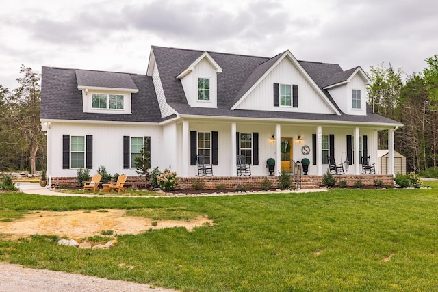 modern farmhouse style home featuring a shingled roof, a front yard, and covered porch