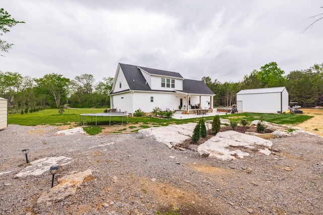 view of front of home with a patio area, an outbuilding, and a trampoline