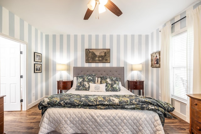 bedroom with baseboards, wood finished floors, and wallpapered walls