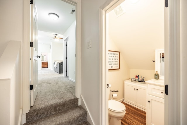 bathroom with ceiling fan, toilet, vaulted ceiling, and visible vents