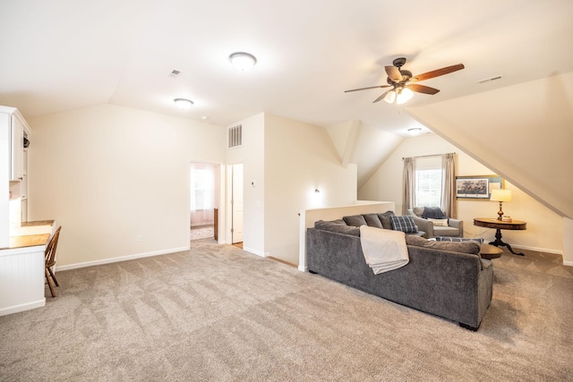 living room featuring lofted ceiling, a ceiling fan, visible vents, and carpet floors