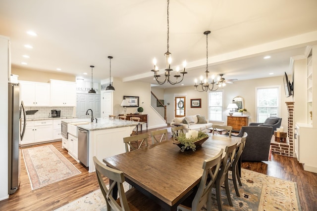 dining room with wood finished floors, recessed lighting, a chandelier, and stairway