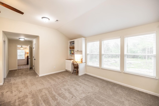 unfurnished room featuring vaulted ceiling, a ceiling fan, baseboards, and light carpet