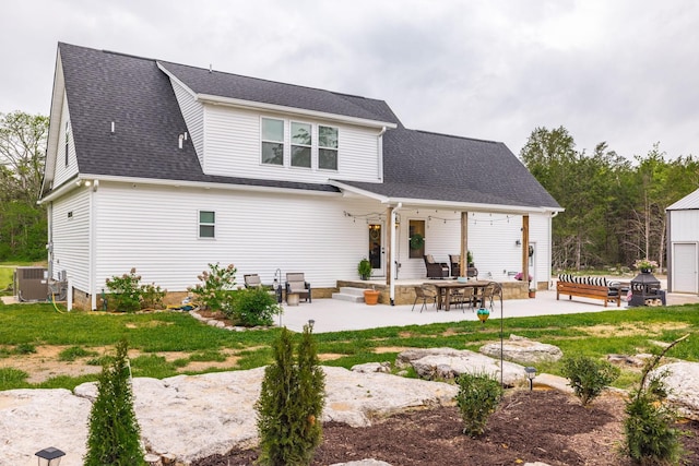 rear view of property with a patio area and a shingled roof