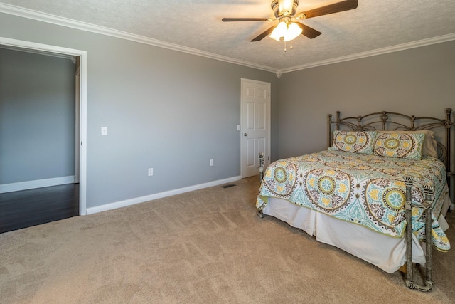 carpeted bedroom with visible vents, a ceiling fan, ornamental molding, baseboards, and a textured ceiling