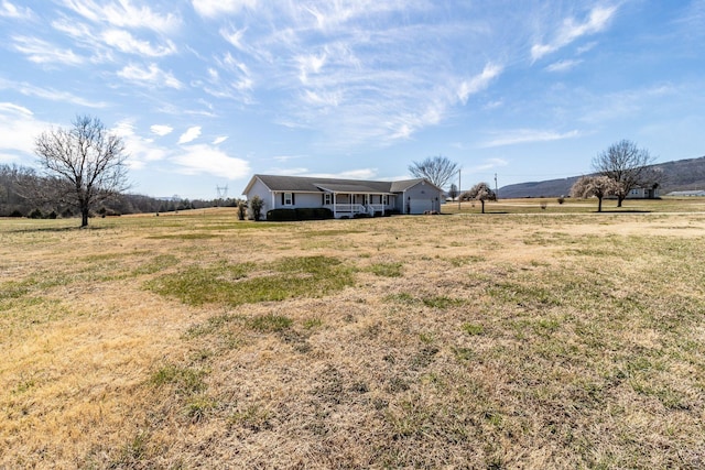 view of yard with a rural view and a garage